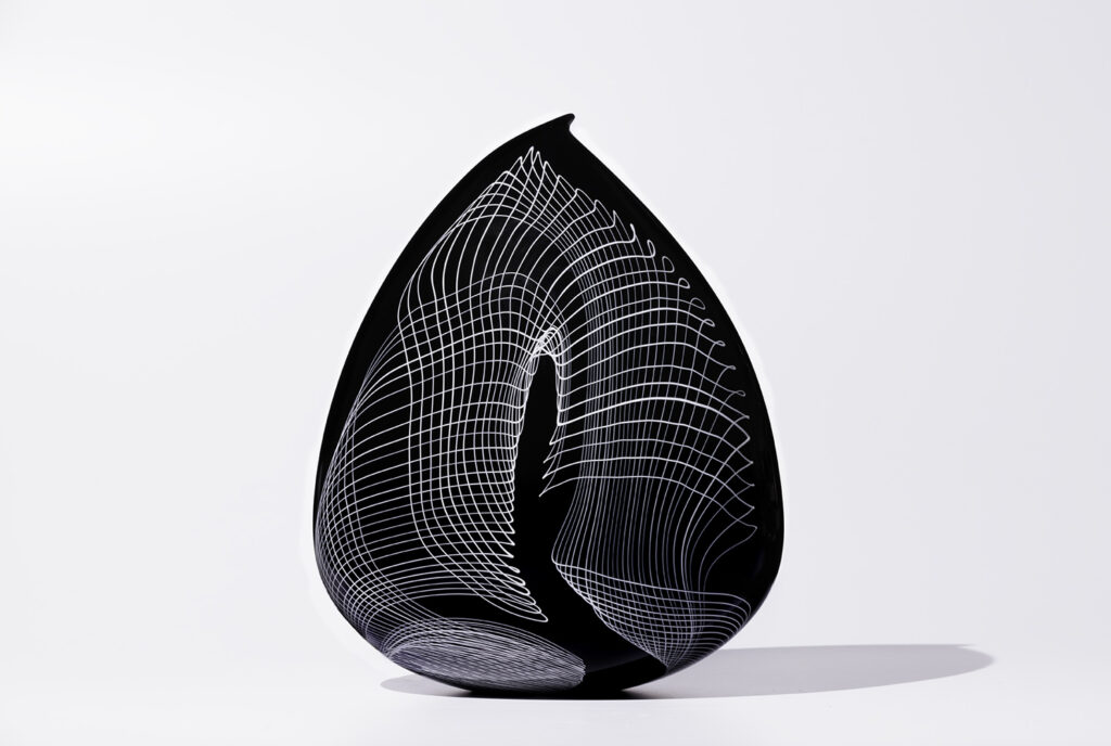 Image of black glass sculpture with teardrop shape and white helix pattern