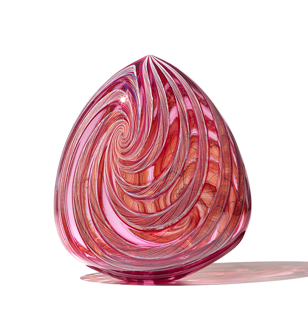 Red and pink glass sculpture with teardrop shape and swirly center