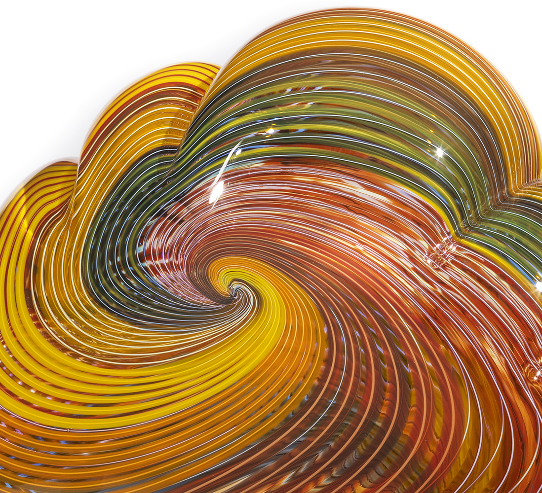 yellow, orange, red and green lines in a spiral arrangement on glass sculpture